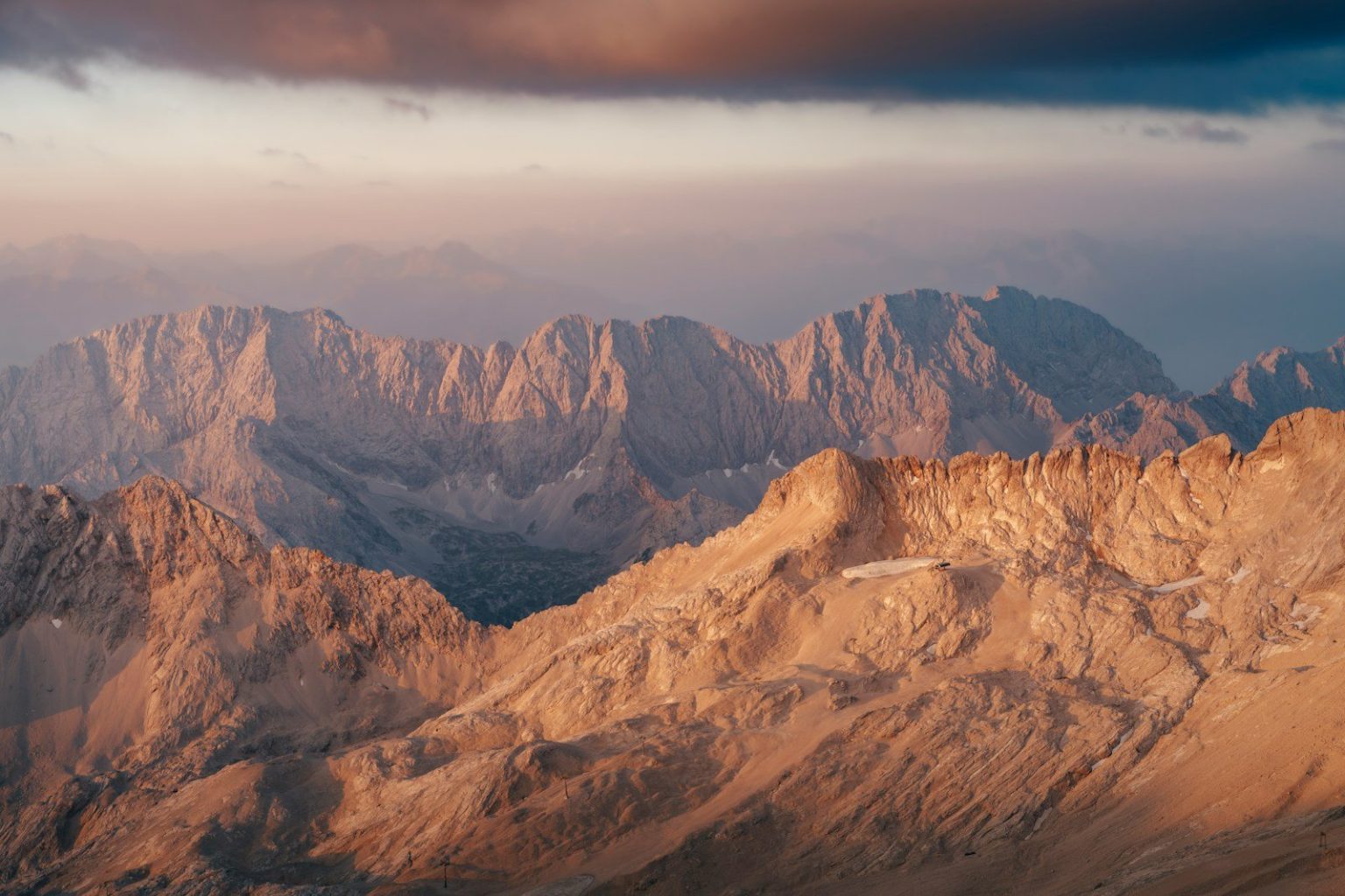 Golden mountain peaks at sunset with dramatic clouds
